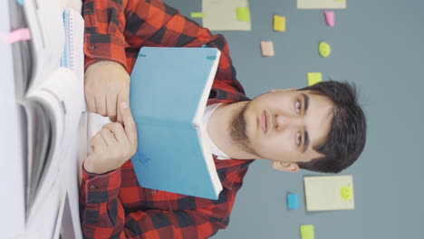 Vertical-video-of-Books-and-unhappy-male-student.